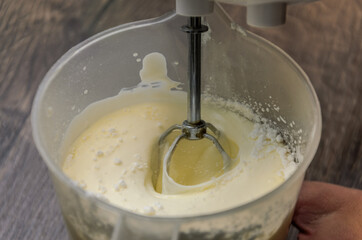 The chef whips the cake cream with an electric mixer	