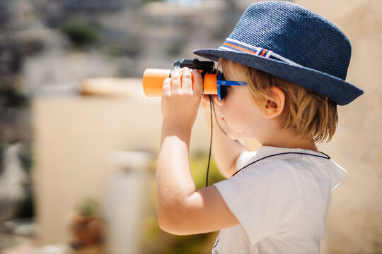 Petit gar&ccedil;on observe avec ses jumelles lors d'une balade en vacances d'&eacute;t&eacute;, printemps