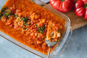 Trout in tomato sauce with vegetables, garnished with parsley