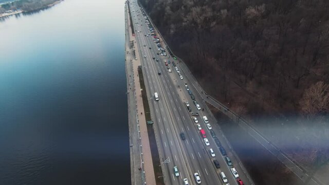 Close up copter view road with driving cars near river. Drone, cars trucks, forest, tourist, water, urban, infrastructure, city, architecture, aerial, travel. Slow motion