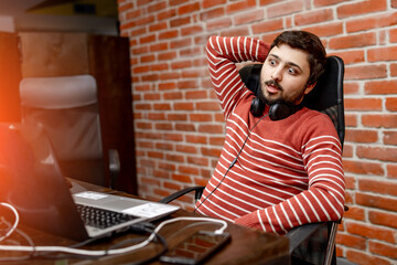Fototapeta premium Attractive young man working at modern office. Creative man in casual cloth sitting at office.