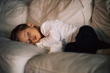 jeune enfant dort dans le divan