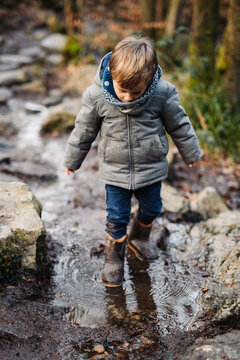 Petit gar&ccedil;on se balade en hiver, marchant dans un ruisseau