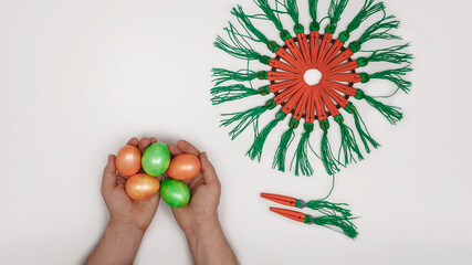 Flat lay demonstrating natural dyed eggs and craft carrots wreath with wooden clothes pins, Eater...
