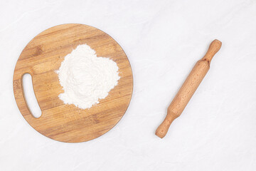White Flour on the wooden board with rolling pin