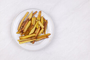 French fries served on the plate with copy space above grey table