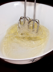 Making a cake: photo catching the movement of an electric whisk used to mixer eggs.
