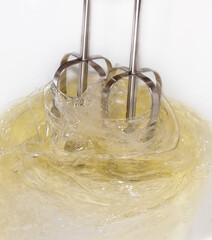 Making a cake: photo catching the movement of an electric whisk used to mixer eggs.