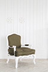 Comfortable vintage armchair in bright living room with minimalist interior and white  walls.