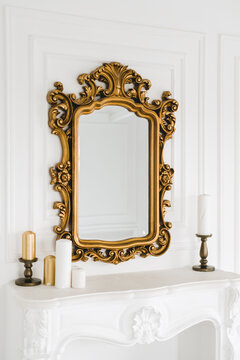 Old vintage mirror with gold colored wooden ornament frame.