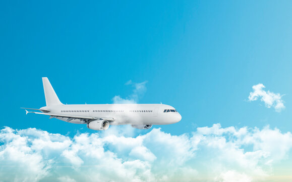 A travel image of a beautiful white modern passenger aircraft flying high in the blue sky above clouds with copy space