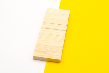 wooden blocks on a yellow and white background. Copy space