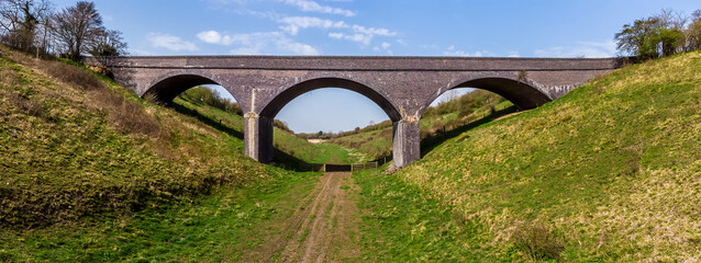 A view towards a Victorian viaduct near to Helmdon village, Northamptonshire, UK on a bright Spring day