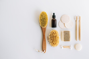 Fototapeta na wymiar Natural eco friendly accessories for self care, dry massage brushes, bamboo toothbrushes, loofah facial sponges and natural soap isolated on white background with copy space.