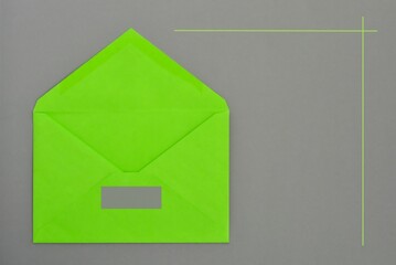 Template bright green open paper envelope  on gray background close-up.