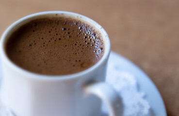 Turkish coffee in a white cup. Black coffee with foam. Traditional delicious hot drink. Selective focus