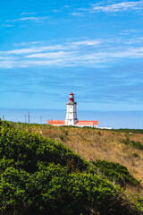 Fototapeta na wymiar The cape Espichel lighthouse viewed from a distance during a summer day