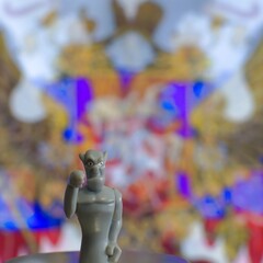 devil figurine close-up on blurred background of multicolored state emblems