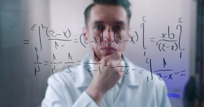 Man Scientist thinks over the solution of the integral equation, drawn on a glass board in a laboratory. The mathematician solves the problem.
