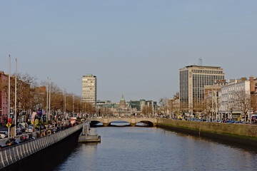 Fototapeta premium river Liffey through the city of Dublin, with historic buildings and bridges and modern office and apartment towers