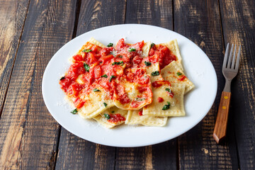 Ravioli with tomato sauce, spinach and parmesan cheese. Healthy eating. Vegetarian food. Italian cuisine.