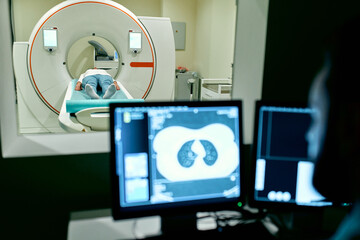 In the medical laboratory, the patient undergoes an MRI or CT scan under the supervision of a radiologist, in the control room, the doctor observes the procedure and monitors the scan results.