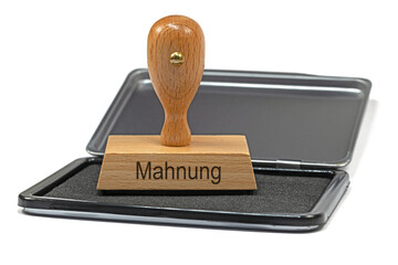 Holzstempel mit der Aufschrift Mahnung