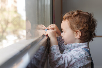 Niño jugando frente a una ventana
