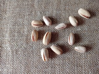 Fototapeta na wymiar pistachios on a burlap background, nuts in the shell