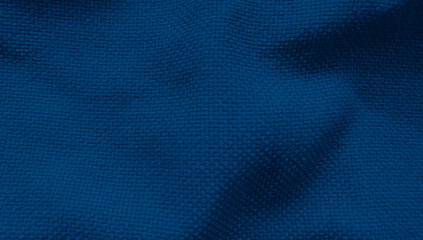 blue crumpled textile fabric for dark mood and tone. synthetic cloth as a background close-up. contrasting folds of fabric.