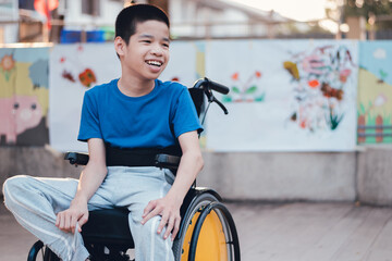 Asian special child on wheelchair is smiling face as happiness on the outdoor nature park background with parent in travel,Lifestyle in education age of disabled children,Happy disability kid concept.