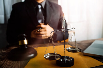 Justice and law concept.Male judge in a courtroom with the gavel, working with, computer and docking keyboard, eyeglasses, on table in morning light
