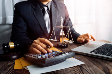Business and lawyers discussing contract papers with brass scale on desk in office. Law, legal services, advice, justice and law concept