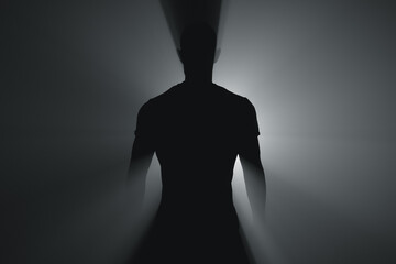 Silhouette of a man in the beams of a spotlight