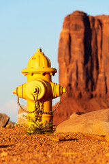 Gelber Hydrant mit einem großen roten Felsen im Hintergrund im Monument Valley in Arizona in den USA