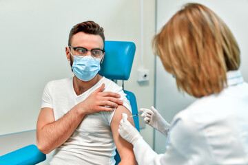 Vaccination, immunization campaign, disease prevention concept. Young man in medical face mask...