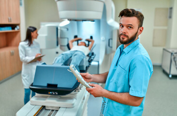 A young woman is undergoing radiation therapy for cancer under the supervision of doctors in a...