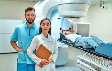 A young woman is undergoing radiation therapy for cancer under the supervision of doctors in a modern cancer hospital. Cancer therapy, advanced medical linear accelerator.