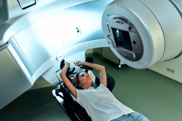 A young woman is undergoing radiation therapy for cancer in a modern cancer hospital. Cancer...