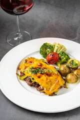 Cheddar cheese beefsteak with potatoes and broccoli on dark stone background