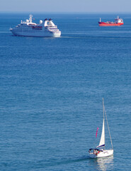 Modern yacht cruise ship or cruiseship liner in the sun light against blue sea ocean and sky in...