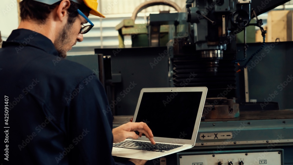 Poster skillful factory worker working with laptop computer to do procedure checklist . factory production 