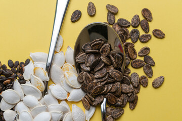 Watermelon, pumpkin and melon seeds on a yellow background