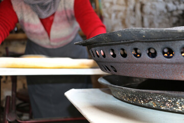 selected focus. A peasant woman organically cooks homemade pasta and dough for her family in the garden of her home.