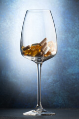 Various vitamins in a wine glass. Close-up.