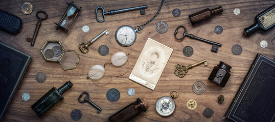 A collection of antique antiques is spread out on the table. Old coins, glasses, photography, glass...