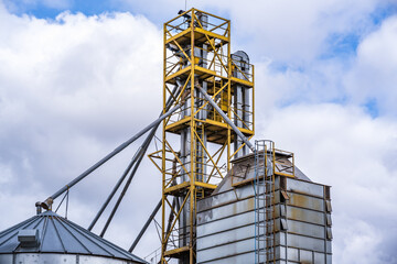 Granary elevator. Silver silos on agro-processing and manufacturing plant for processing drying cleaning and storage of agricultural products, flour, cereals and grain.