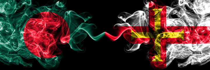 Bangladesh, Bangladeshi vs United Kingdom, Great Britain, British, Guernsey  smoky mystic flags placed side by side. Thick colored silky abstract smokes flags.