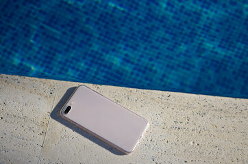 Clear phone case mockup in hand on the background of the swimming pool smartphone back view