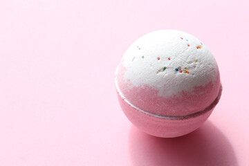 DIY Birthday Cake Bubble Bath Bomb with sprinkles on pink background. Pink salt bomb on colored pastel backdrop. Top view, copy space. Natural beauty spa body care product
